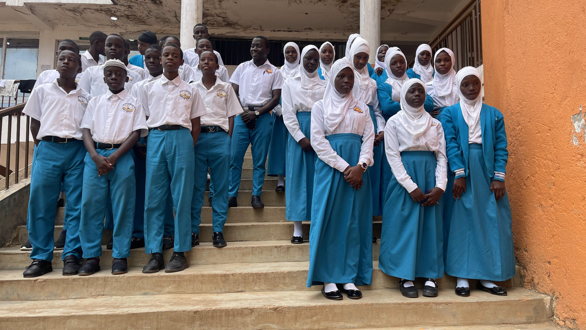 Students in school uniforms on steps